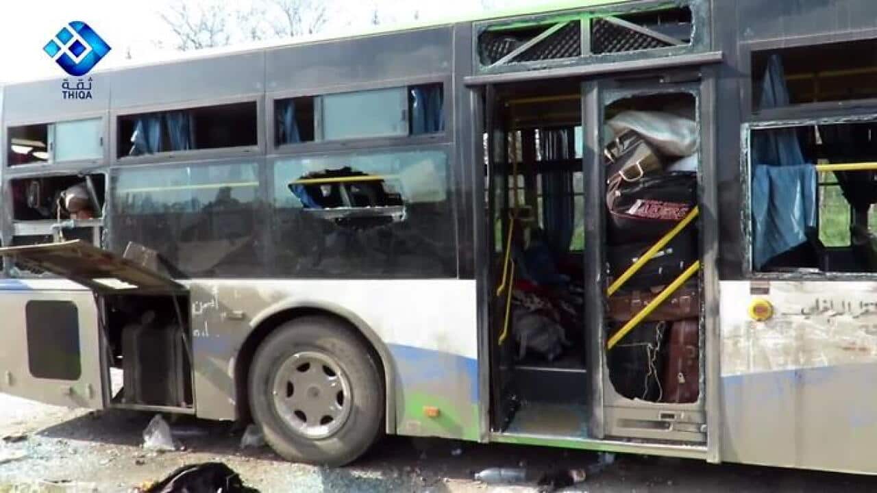 A handout photo made available by Thiqa News Agency (TNA) showing a damaged bus at the scene of a car bomb attack that targeted buses evacuating civilians (AAP)
