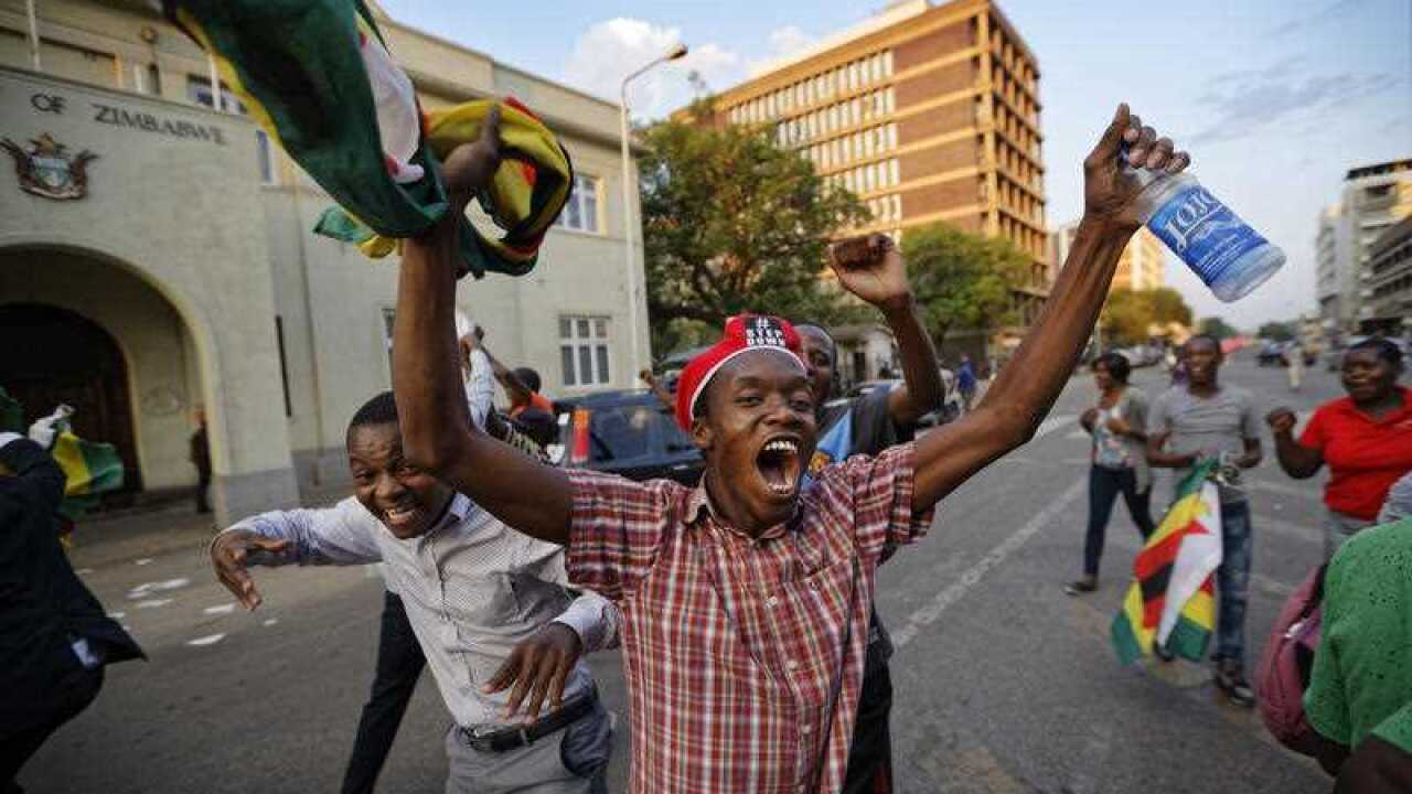 Zimbabweans celebrate outside the parliament building immediately after hearing the news that President Robert Mugabe had resigned, in downtown Harare, Zimbabwe Tuesday, Nov. 21, 2017.