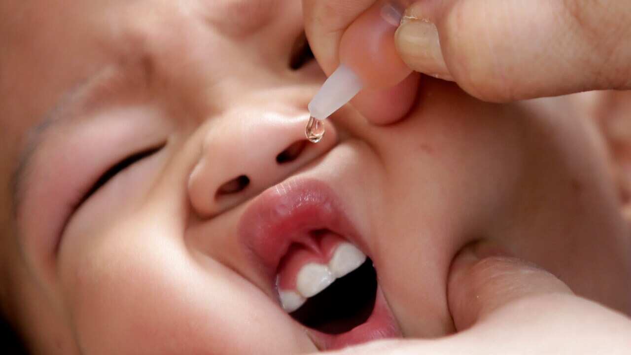Health worker delivers a vaccine to a baby, east of Manila