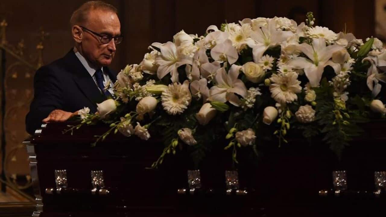Former NSW Premier Bob Carr walks past and touches the casket