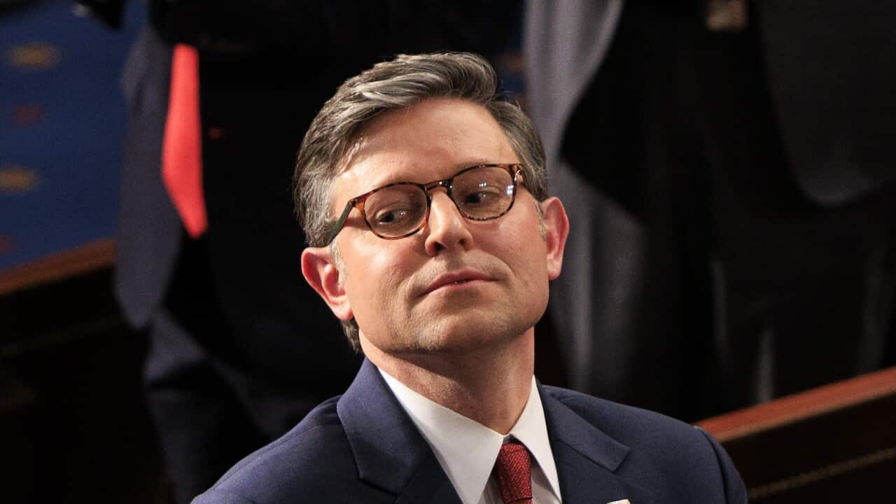 Mike Johnson wearing a blue suit, white shirt and red tie.