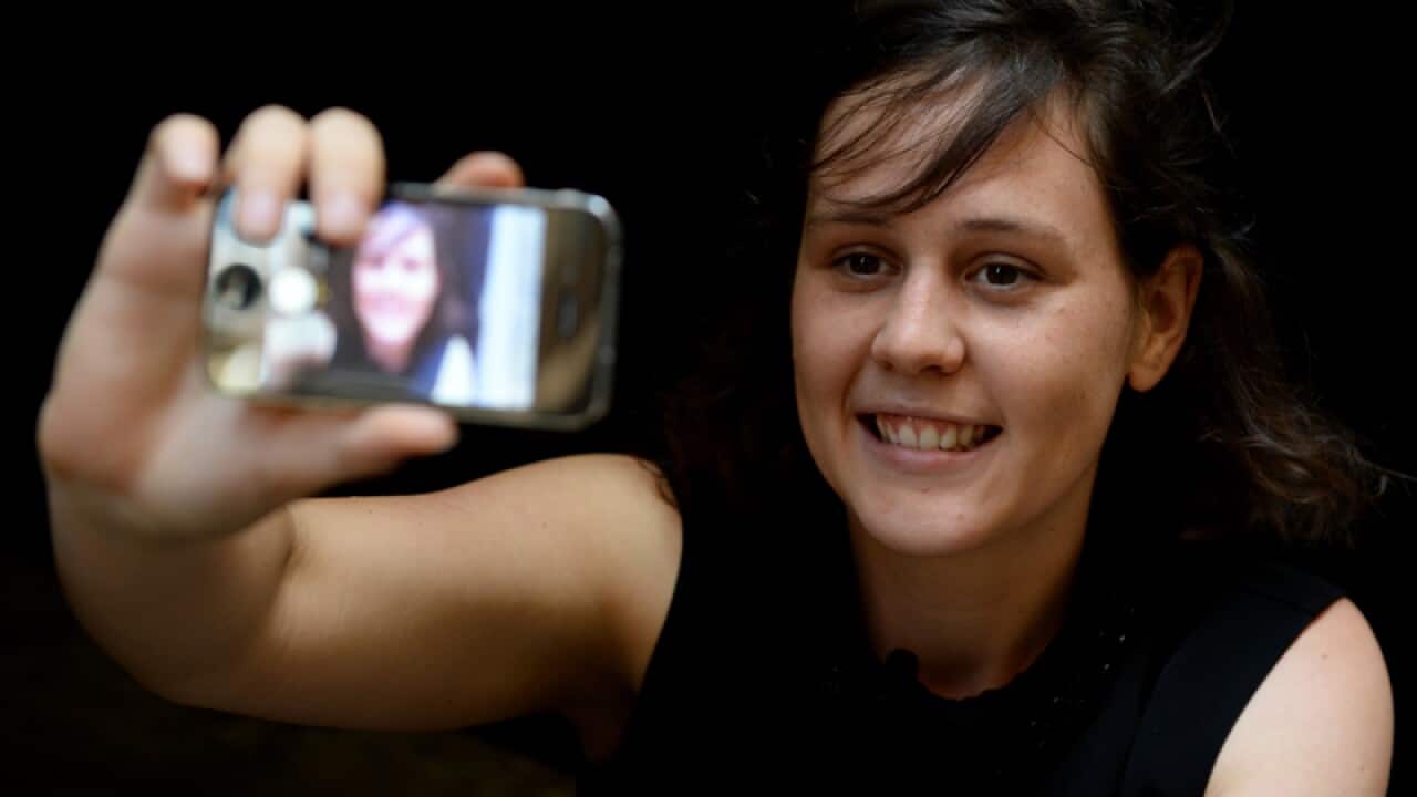 A woman takes a 'selfie' photograph of herself with a smartphone, Sydney, Wednesday, Nov. 20, 2013. (AAP Image/Dan Himbrechts) NO ARCHIVING