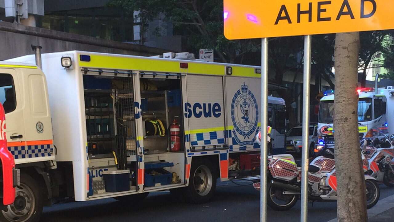 Emergency services at the scene of a woman pinned under a bus