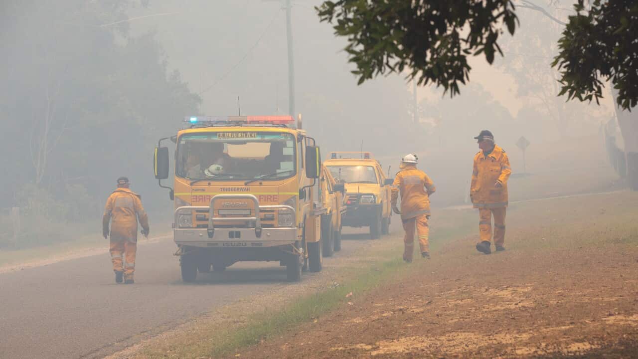 Firefighters and helicopters tackle the fires at Cooroibah in Noosa Shire.