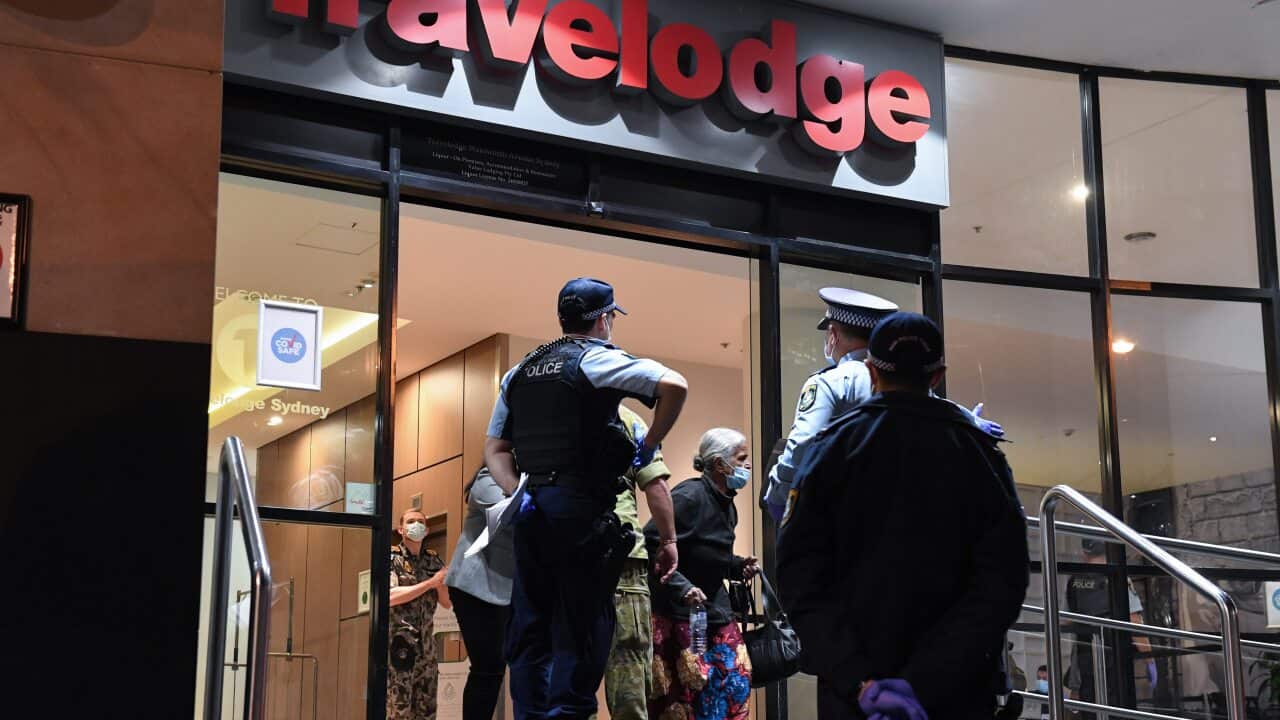 Guests departing Sydney's Travelodge under police guard on 25 August, 2020.