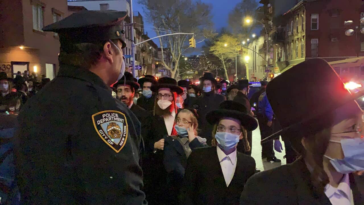 A new York City police officer keeps watch as hundreds of mourners gather in the Brooklyn borough of New York.