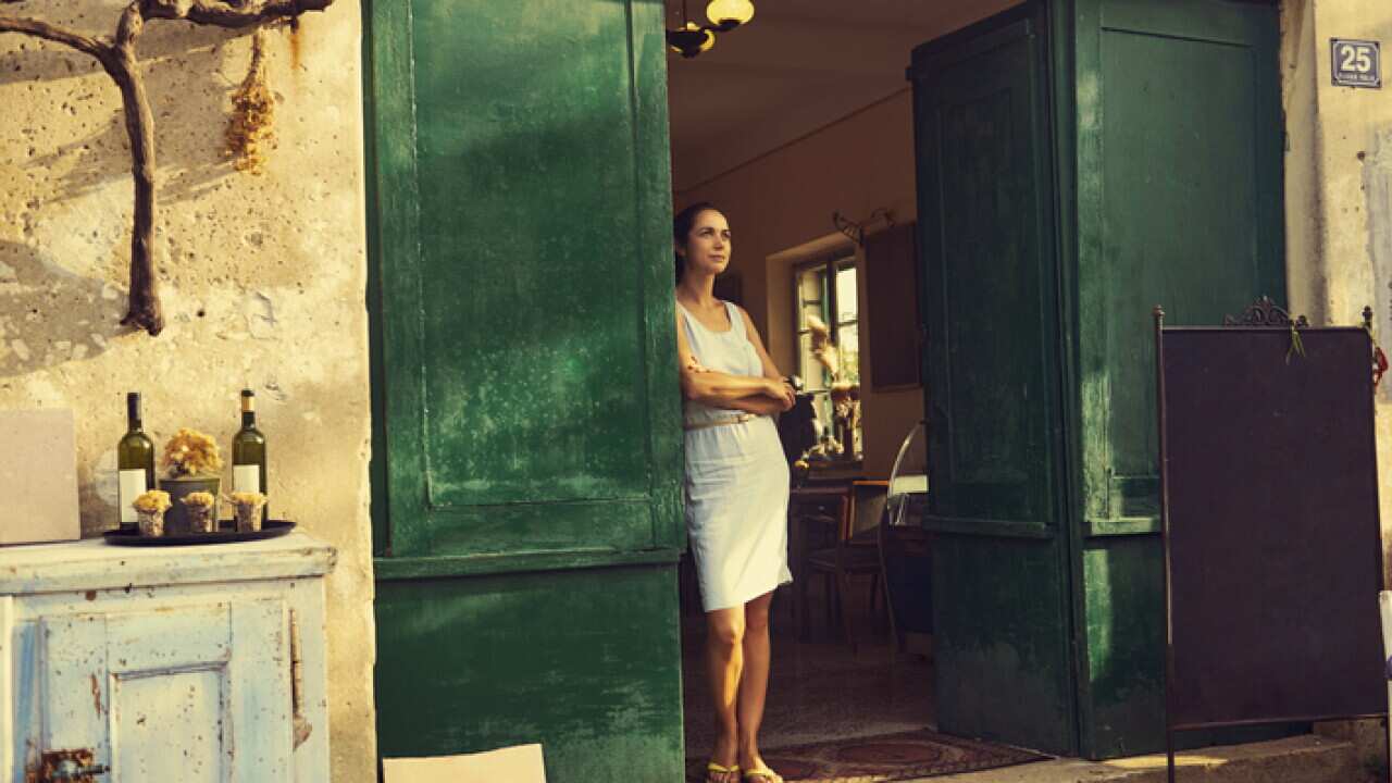 woman standing in front of a tavern