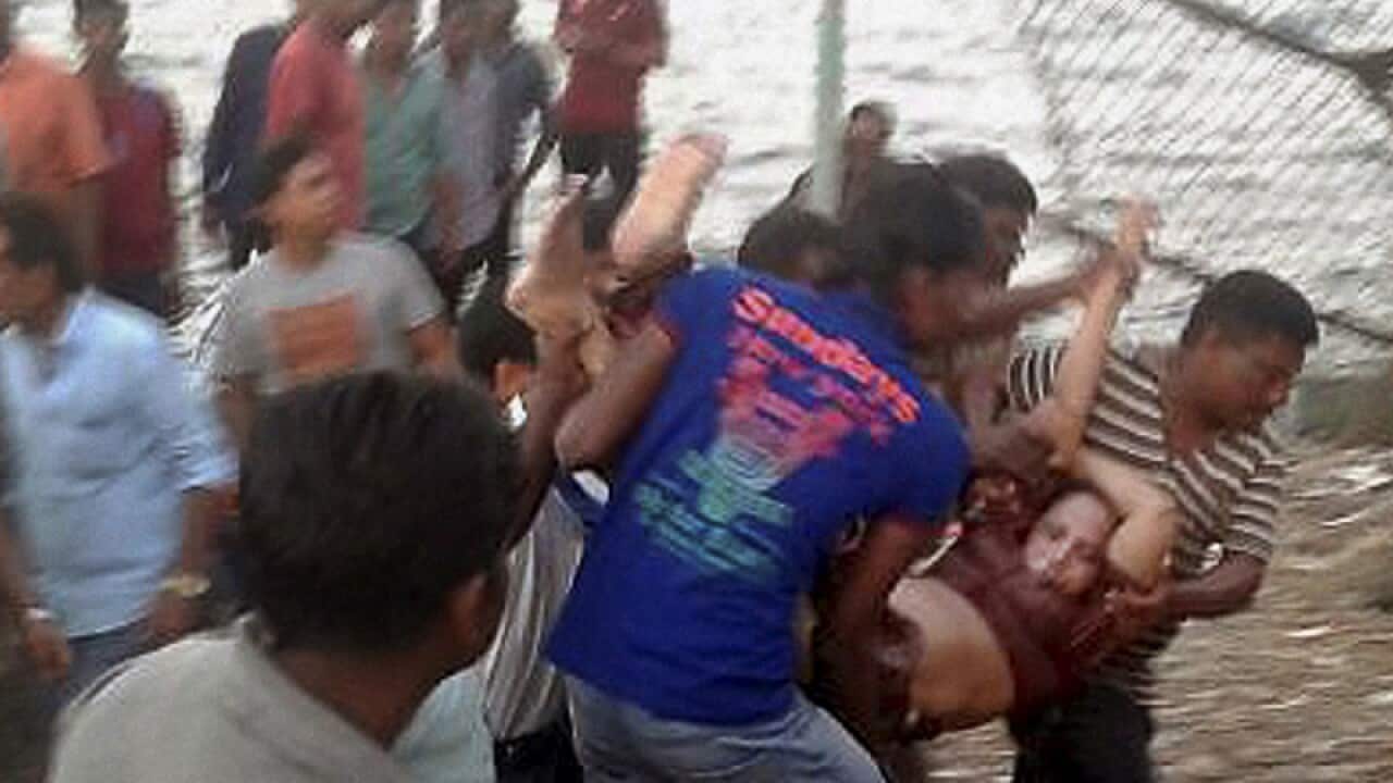 Indian rescuers carry a woman after a boat capsized, India