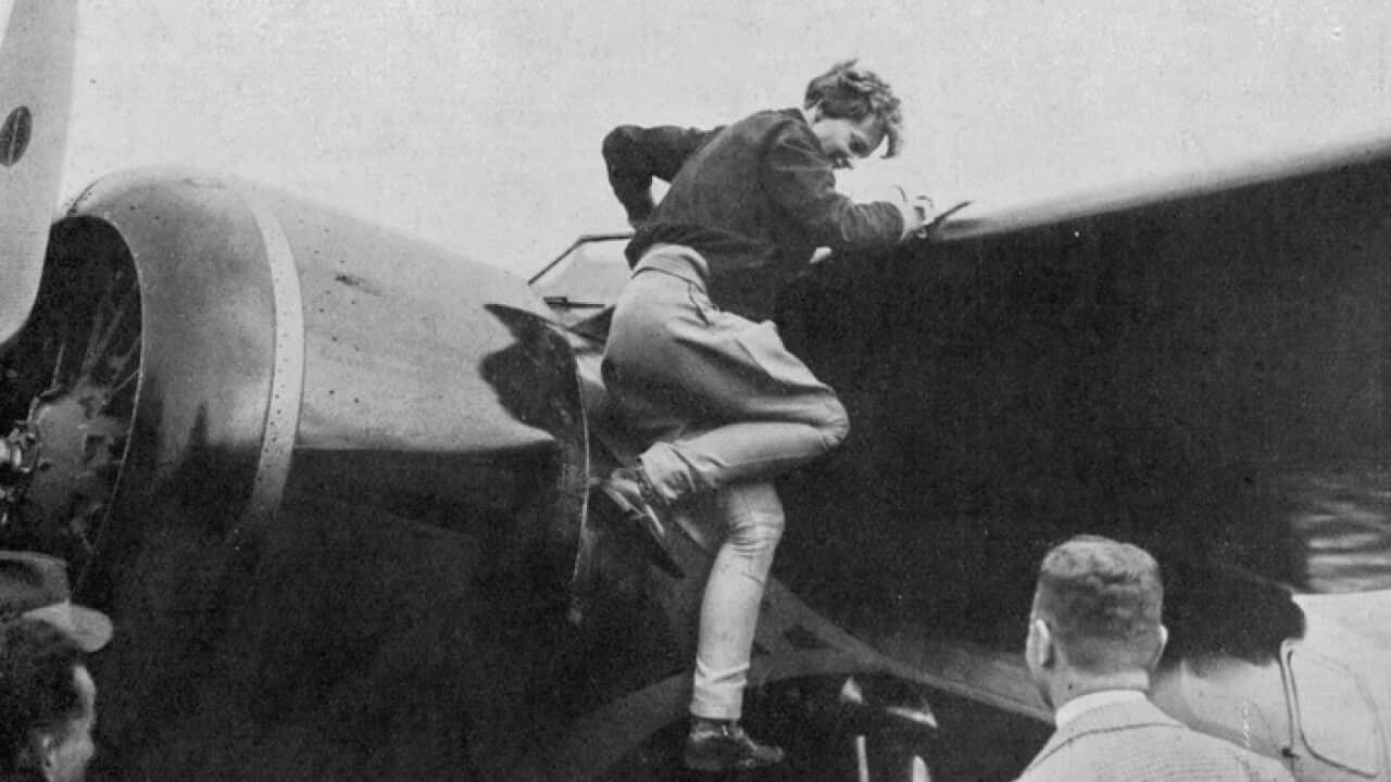 Amelia Earhart lowers herself  from her aircraft at  Londonderry after her solo  transatlantic flight West to  East. Date: 1932