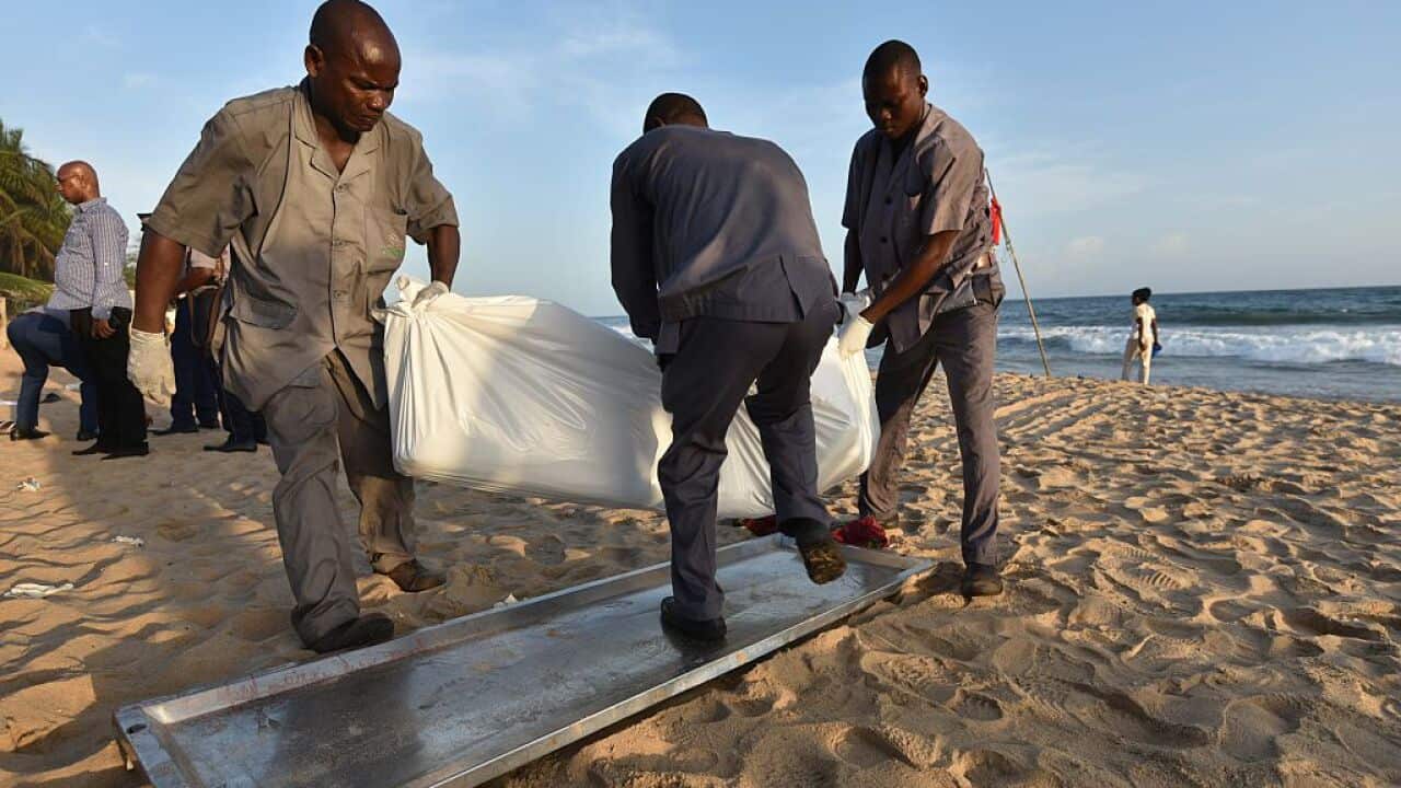People carry the body of a victim following after gunmen went on a shooting rampage in the Ivory Coast resort of Grand-Bassam, on March 13, 2016.