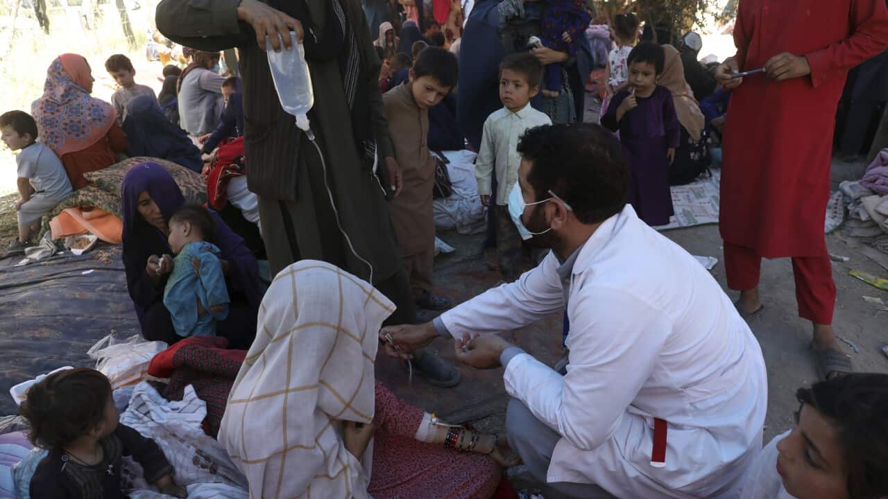 Displaced women from Afghanistan receive medical care at a public park.