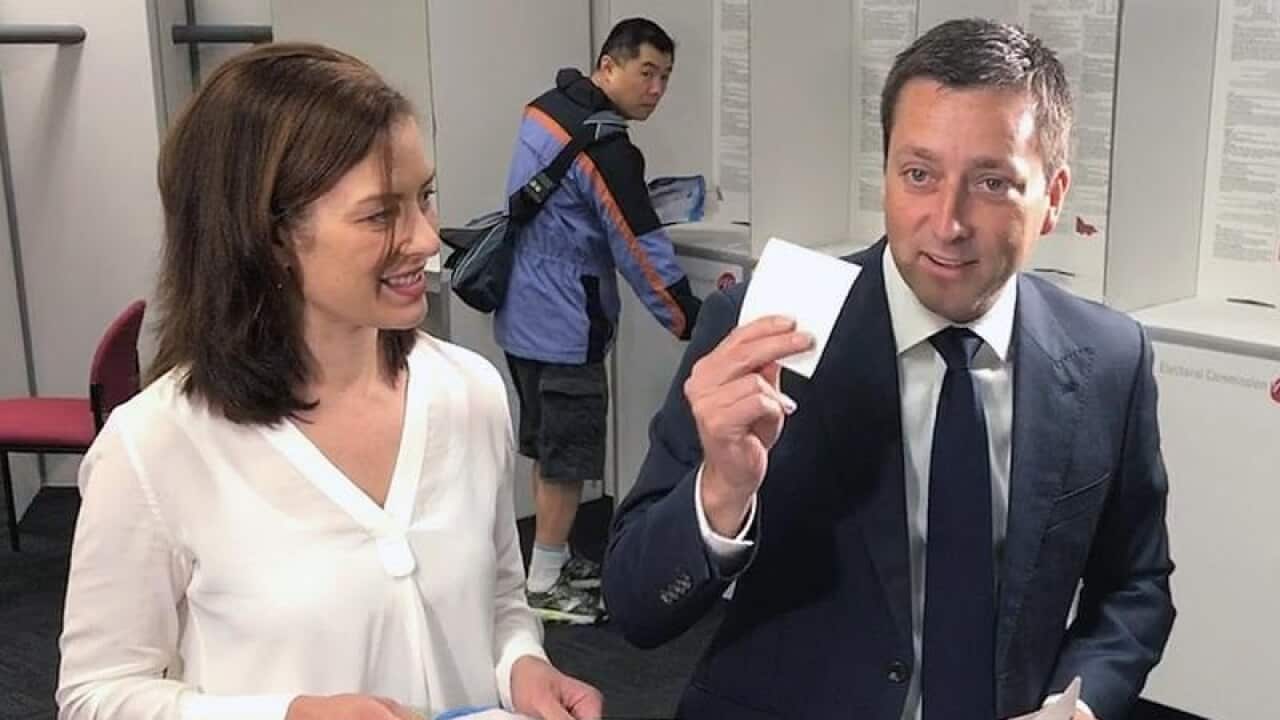Matthew Guy (C) casts his ballot in the state election