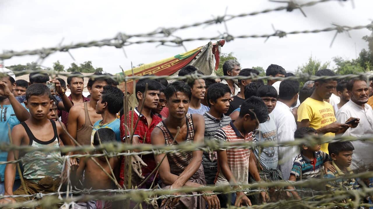 Rohingya refugees gather near a fence at the 'no man's land' zone at the Bangladesh-Myanmar border in Maungdaw district, Rakhine State, 24 August 2018.