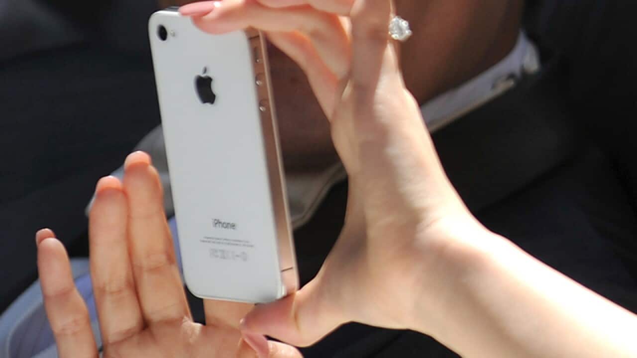 A woman taking a picture with an iPhone