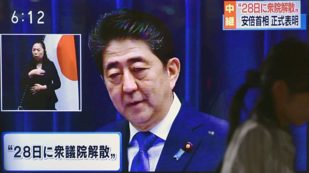 A TV screen showing a press conference by Japanese Prime Minister Shinzo Abe in Tokyo