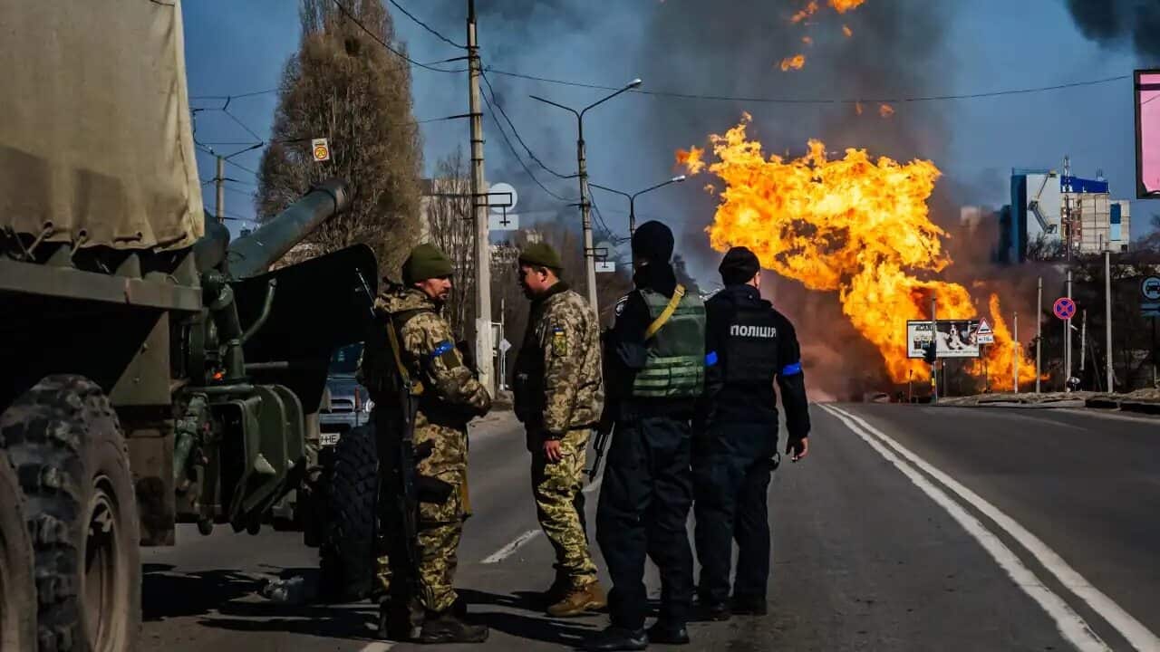 Ukrainian police and soldiers stand ready with an artillery unit after a Russian bombardment destroyed a building near their position, in the Moskovskyi district in Kharkiv, Ukraine.