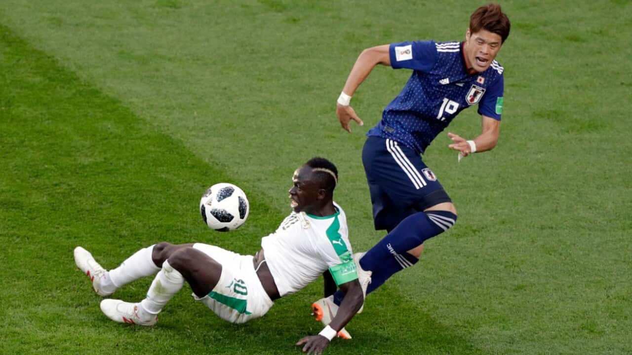 Senegal's Sadio Mane, left, is tackled by Japan's Hiroki Sakai