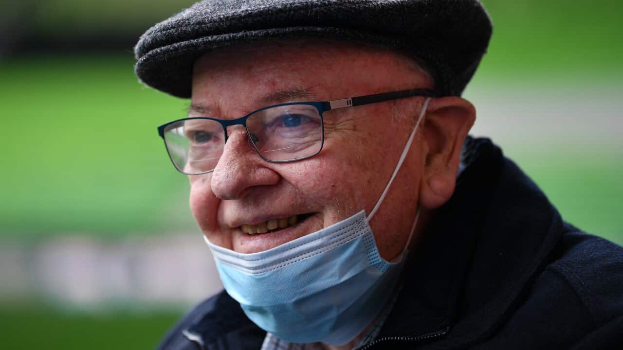 Father Bob Maguire seen smiling, with a face mask on his chin