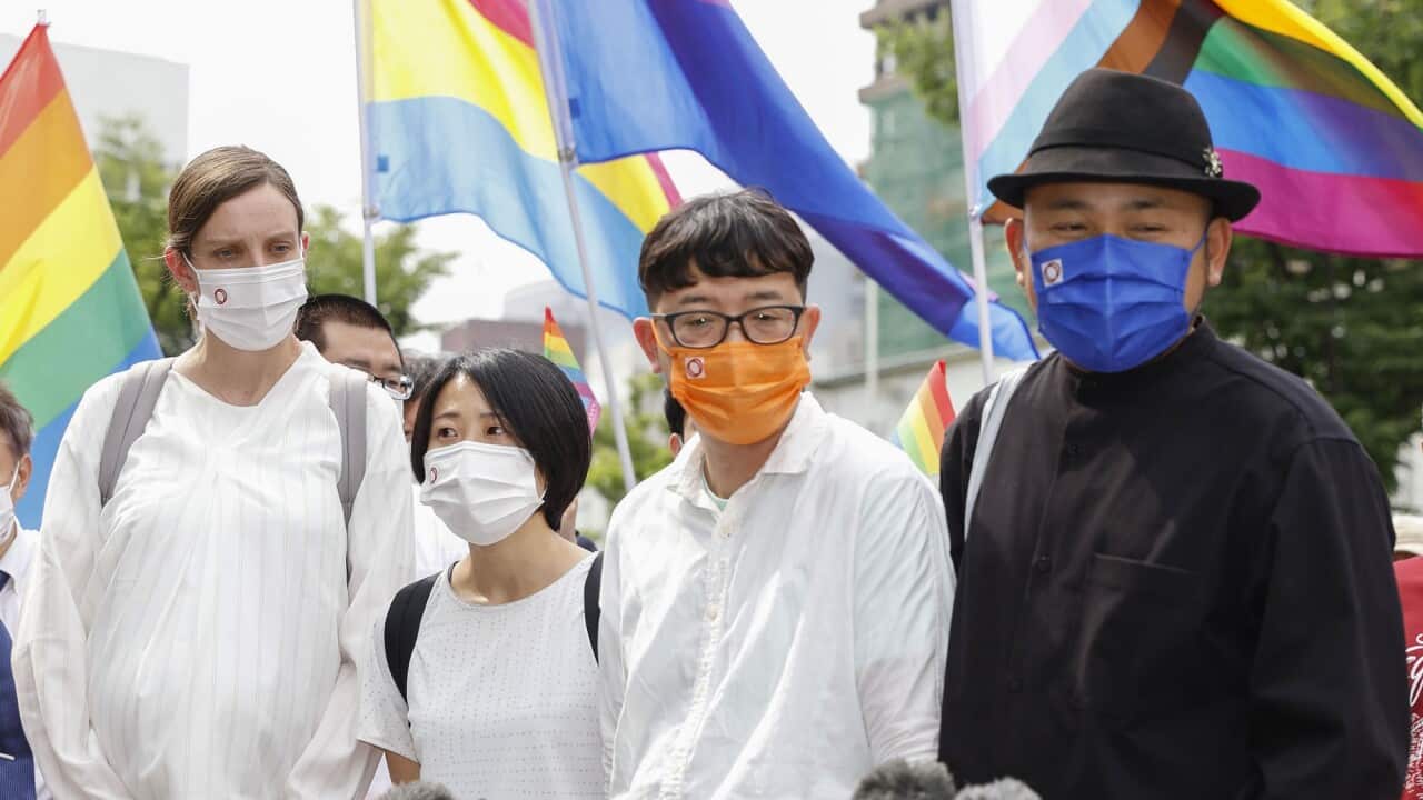 Plaintiffs speak to journalists after the Osaka District Court ruling on 20 June 2022.