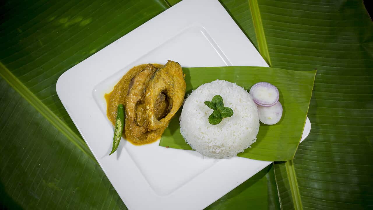 Traditional Indian Fish Curry with Rice on Banana Leaf
