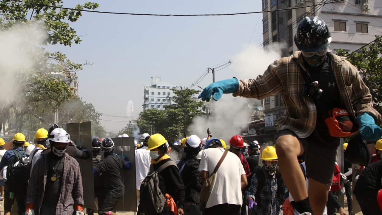 Protesters are dispersed as riot police fire tear gas behind a makeshift barricade in Yangon, Myanmar, Sunday, 7 March, 2021.