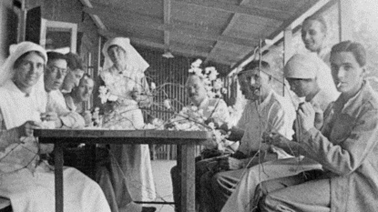 Patients and nurses of Ward 31, Colaba War Hospital, Bombay, make Christmas decorations on the verandah of the ward.