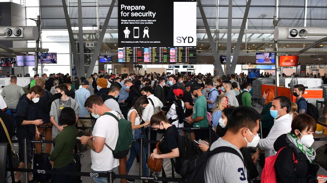 Huge queues are seen at the Virgin and Jetstar domestic departure terminal at Sydney Domestic Airport in Sydney, Friday, April 8, 2022. Domestic airline travels are queued outside the airport, forced to wait hours to get through check in and security. (AA
