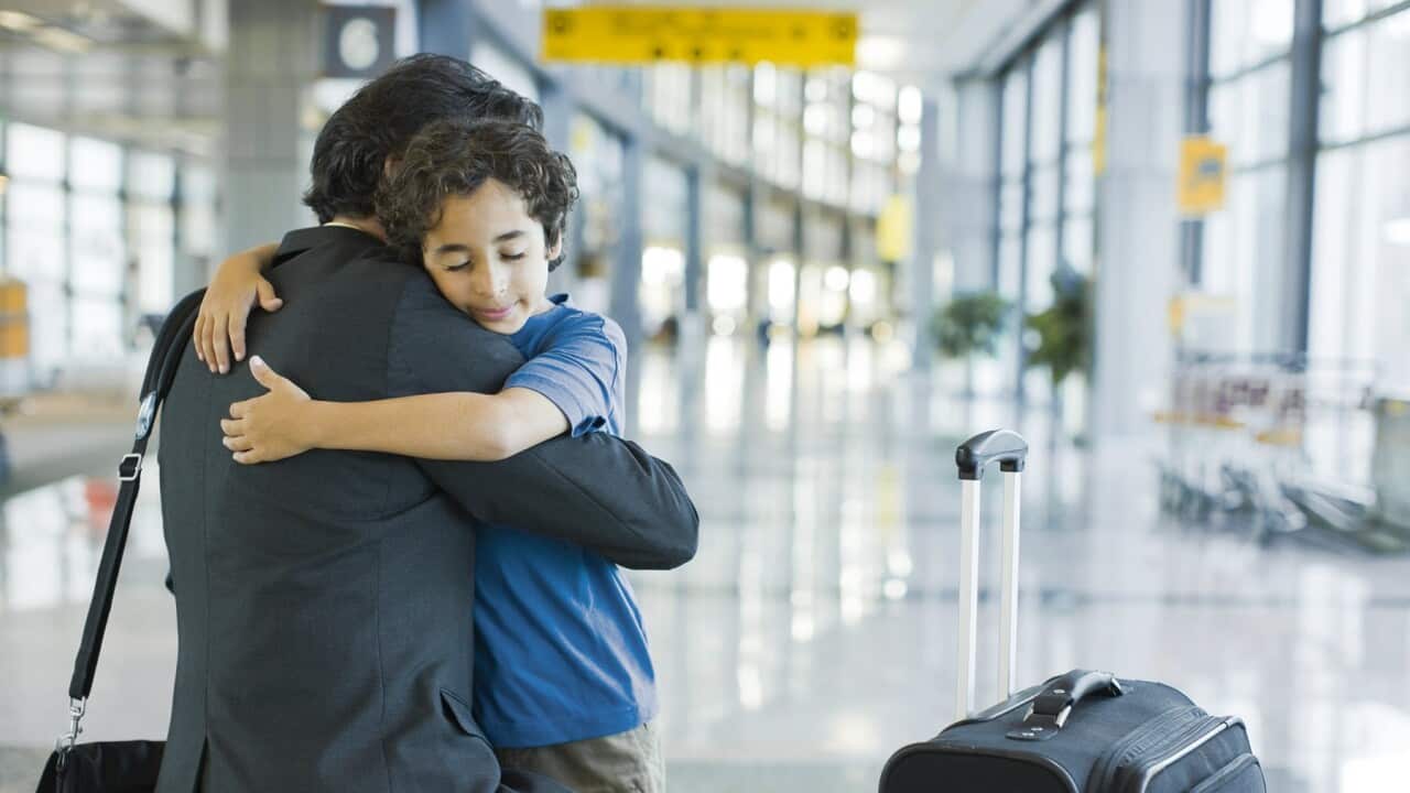 A man is hugging a child at an airport (Getty Images)