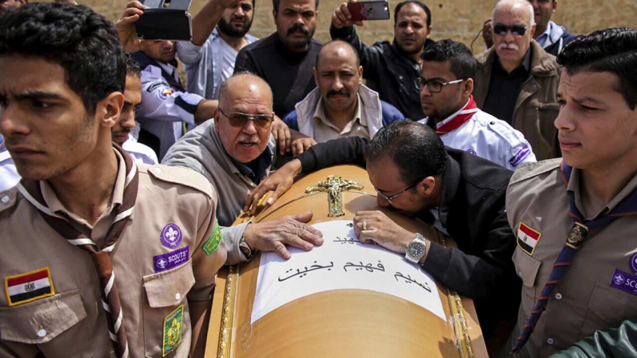 A coffin arrives for the funeral of those killed in a church attack