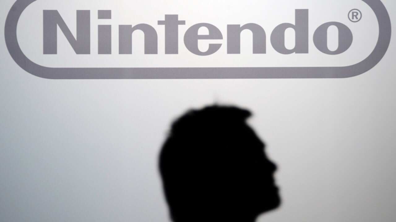 A visitor walks by a Nintendo logo