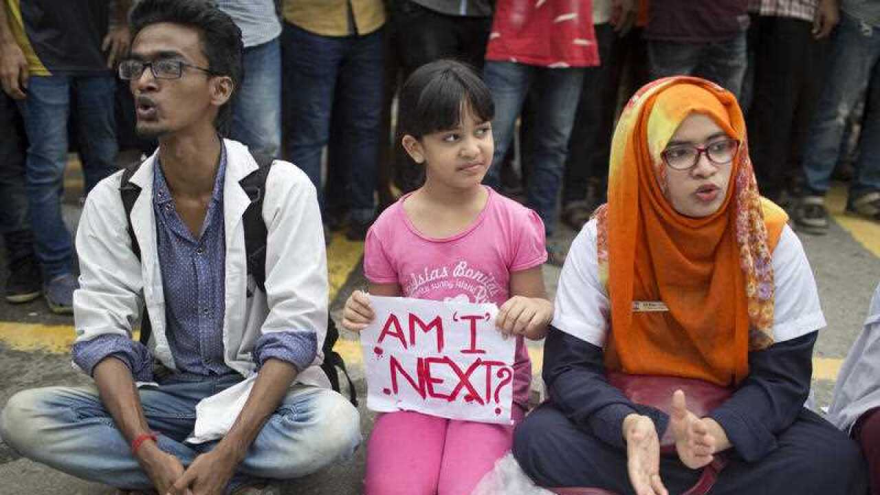 A Bangladeshi child holds a placard, as she participates with protesting students in Dhaka, Bangladesh.