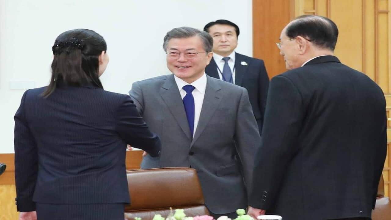 South Korean President Moon Jae-in (C) shakes hands with Kim Yo-jong