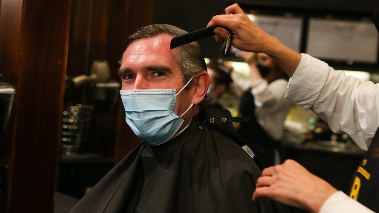 NSW Premier Dominic Perrottet receives a hair cut as lockdown restrictions ease.