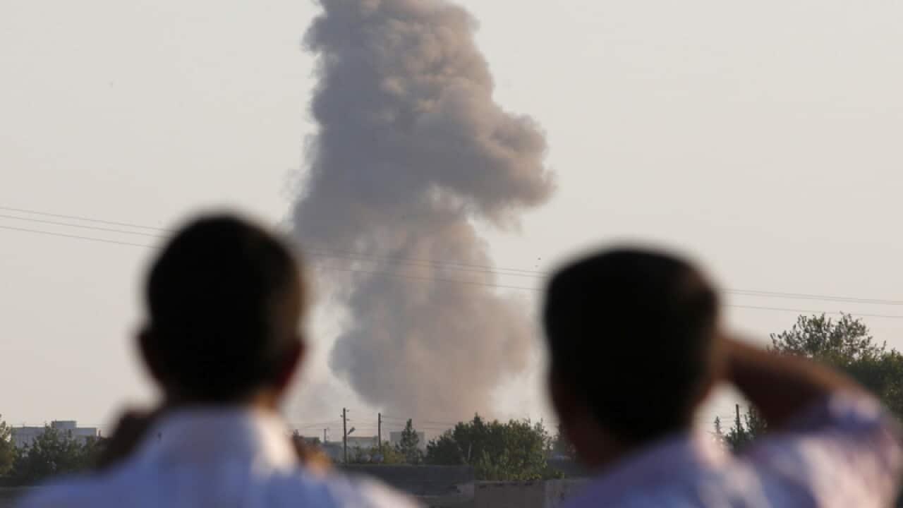 Turkish Kurds watch smoke rise following an airstrike in Kobane