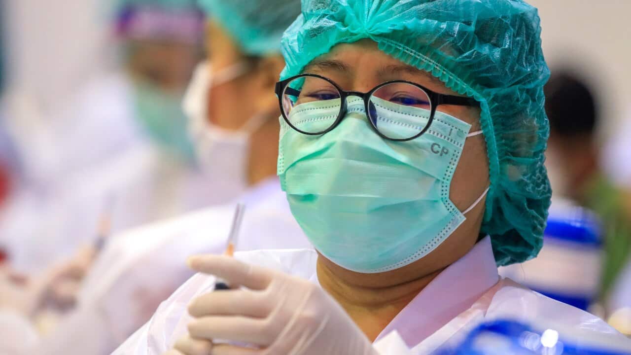 A Thai health official administers the Sinovac vaccine to Bangkok shopping mall staff