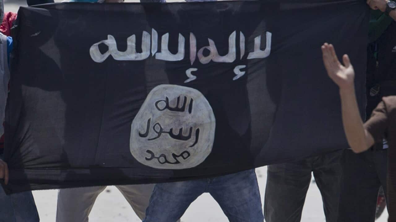 Kashmiri Muslim protesters hold a flag of Islamic State
