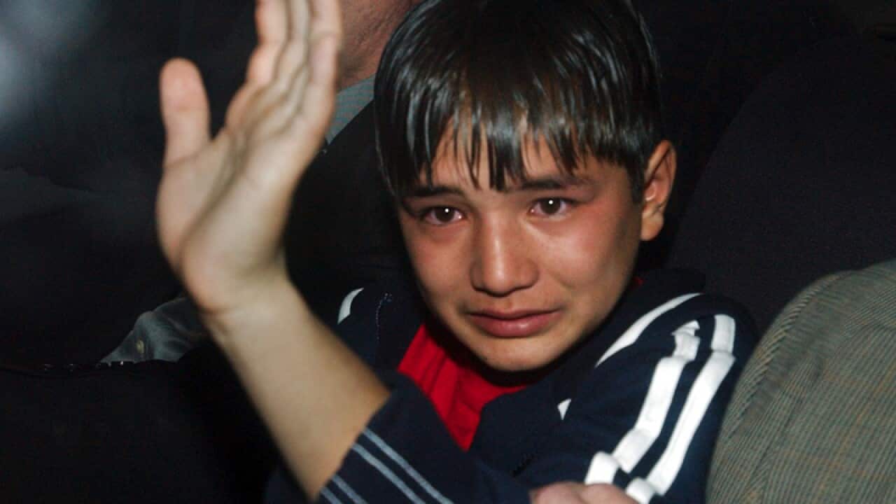 One of two child asylum seekers is led away into custody