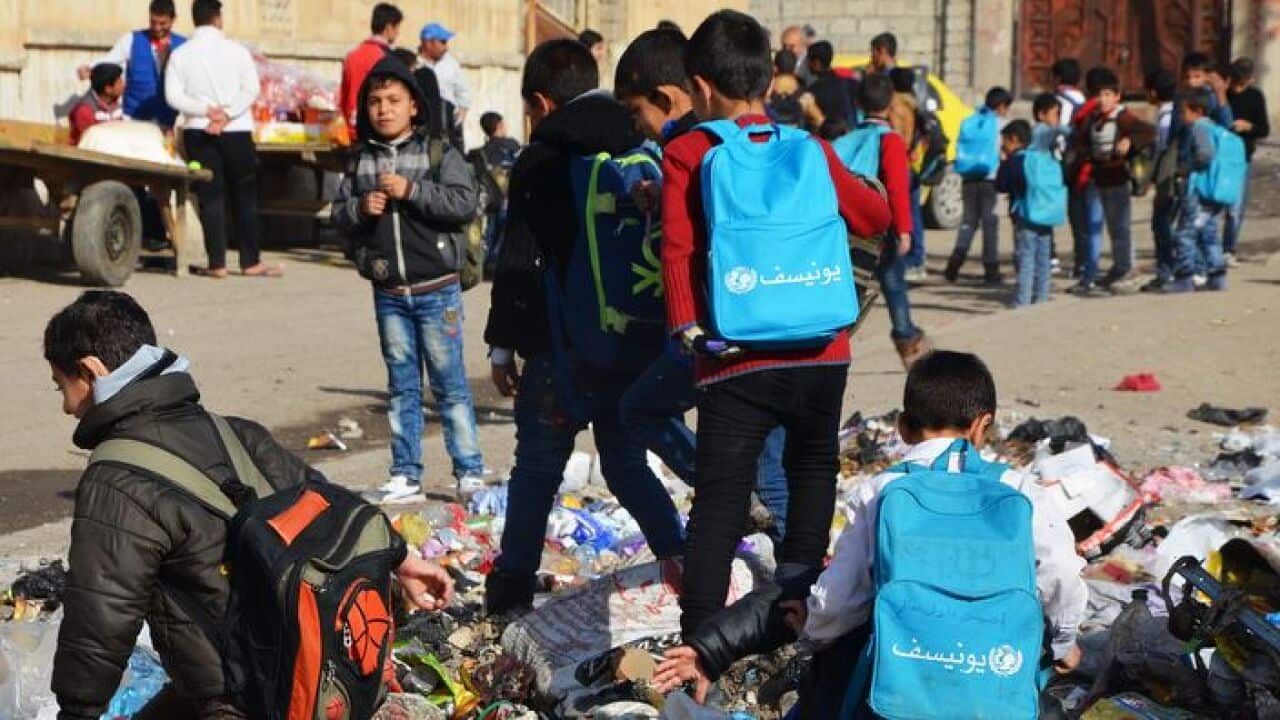 Iraqi children walk to school in the battered city of Mosul on December 27, 2017.