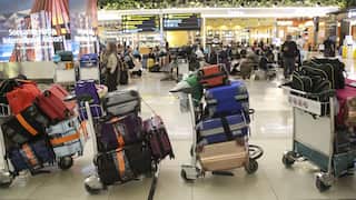 Luggage trolleys loaded with bags at an airport.