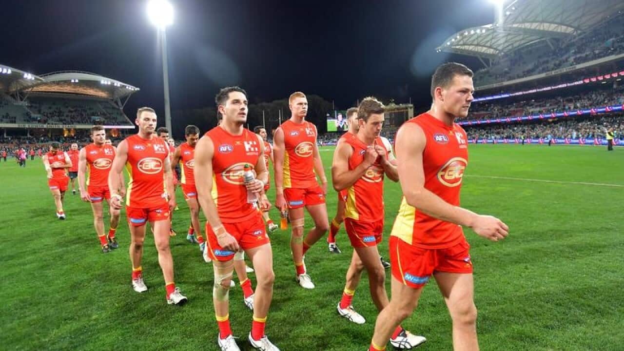 Gold Coast players trudge off Adelaide Oval.