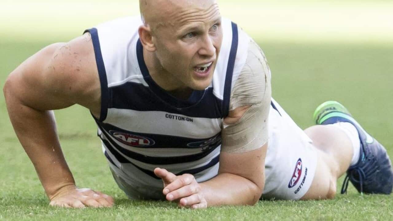 AFL player Gary Ablett pushes himself up from the ground.