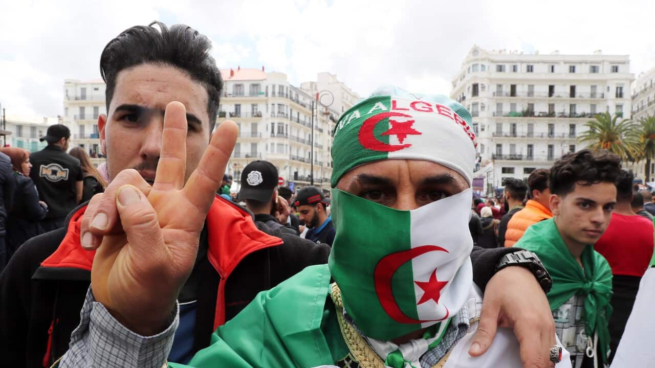 Algerians gesture during a protest against interim President Abdelkader Bensalah, in Algiers, Algeria.