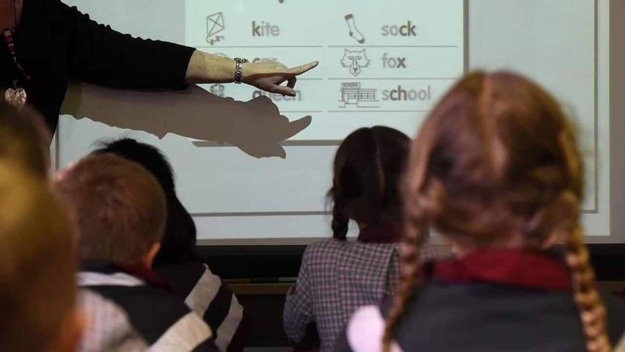 A file image of school students with their teacher in a classroom.