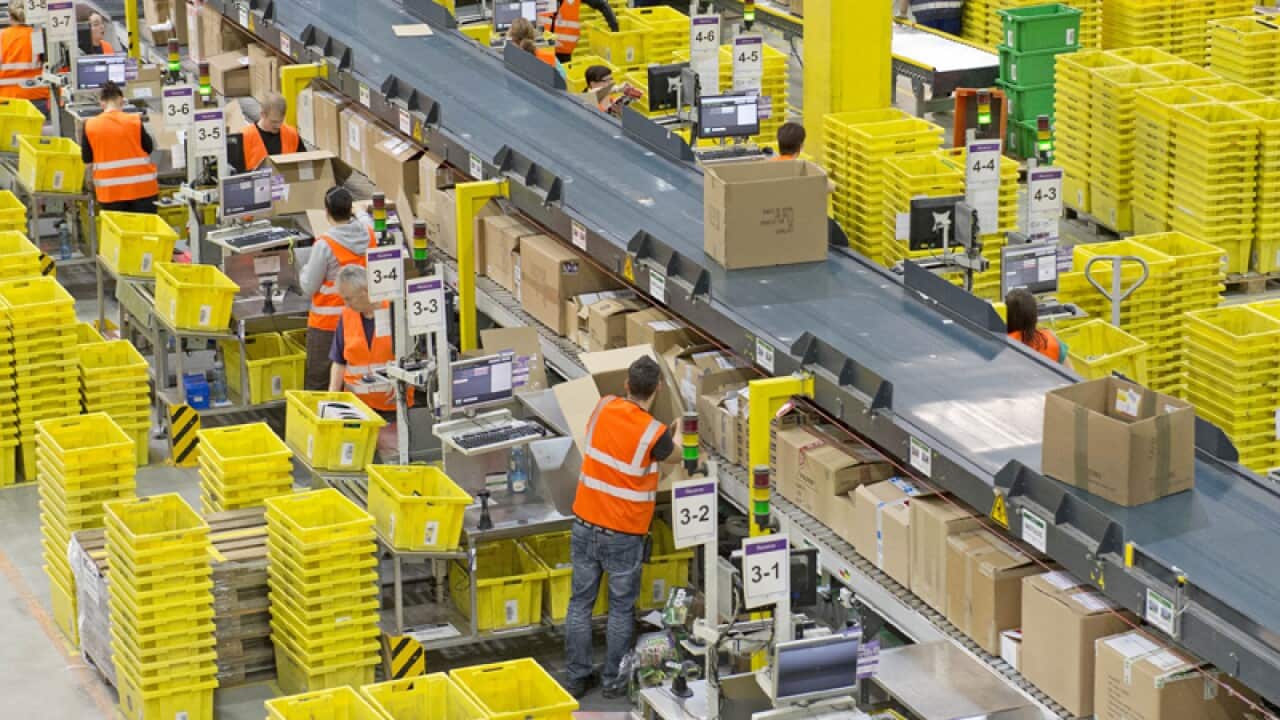 Employees work at a distribution centre of Amazon