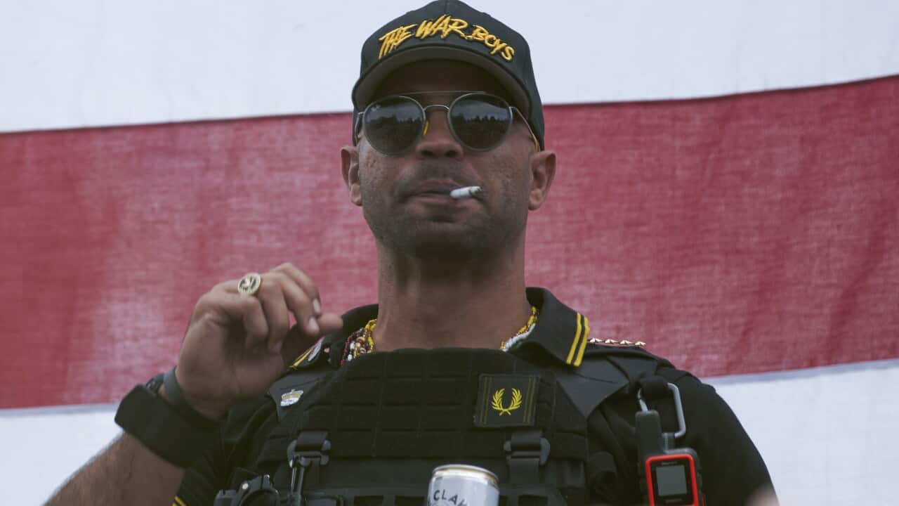 Proud Boys leader Enrique Tarrio wears a hat that says The War Boys at a rally in September.