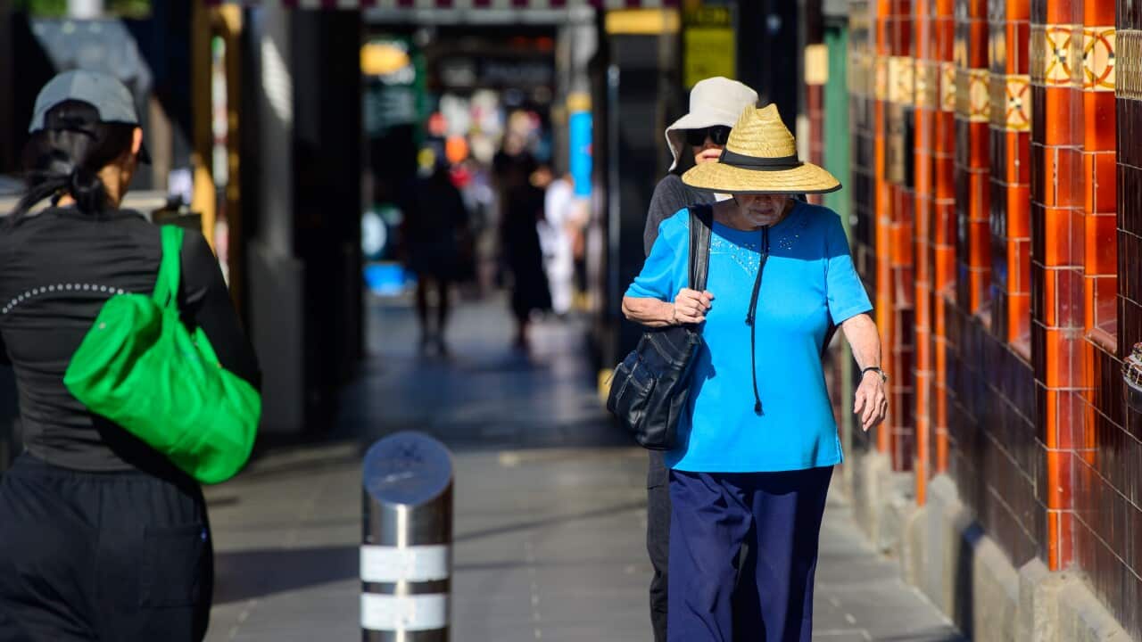 Person walking in hat in a busy street