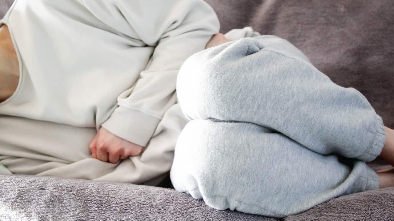 A woman lies down in pain (Getty Images)
