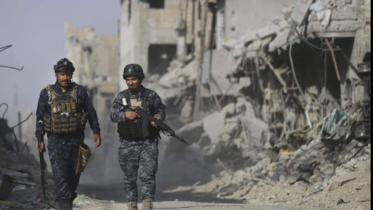 Iraqi soldiers walk in Mosul
