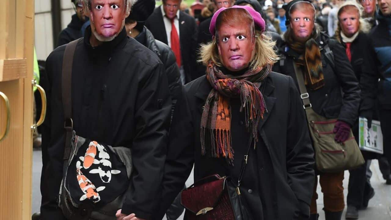 People wearing masks of Donald Trump take part in the 32nd Annual April Fools Day Parade in New York.