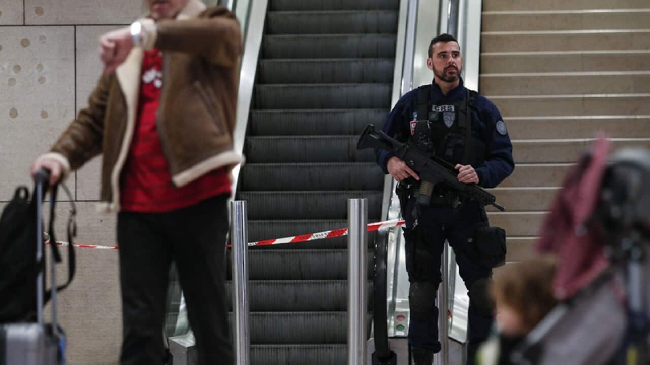 A riot police officer patrols inside Orly airport